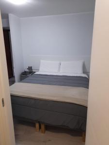 um quarto com uma cama grande e almofadas brancas em Your Independent Room em Lecco
