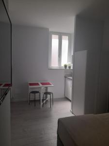 uma pequena cozinha branca com mesa e cadeiras em Your Independent Room em Lecco