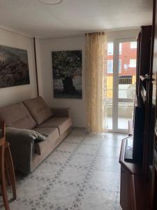 - un salon avec un canapé et une fenêtre dans l'établissement Apartamento de verano 1 habitación, à Ajo