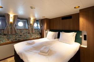 ein Schlafzimmer mit einem großen Bett mit zwei Handtüchern darauf in der Unterkunft Hotelboot Koningin Emma I Kloeg Collection in Vlissingen