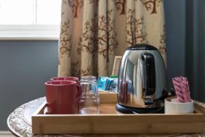 a coffee maker and cups on a wooden tray at Severnside Press BnB in Newnham