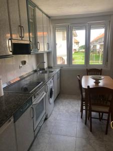 a kitchen with a table and a sink and a dishwasher at Apartamento de verano 1 habitación in Ajo