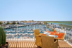 a balcony with a table and chairs and a marina at AP Eva Senses in Faro