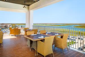 a restaurant with tables and chairs on a balcony at AP Eva Senses in Faro