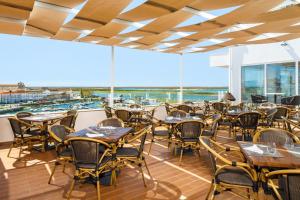 a restaurant with tables and chairs and a view of the harbor at AP Eva Senses in Faro