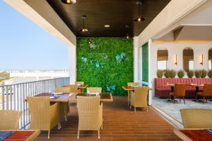 a restaurant with tables and chairs and a green wall at AP Eva Senses in Faro
