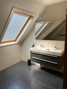 La salle de bains est pourvue d'un lavabo et d'un miroir. dans l'établissement Appartement Zilt, à Hollum