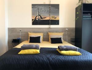 1 dormitorio con 1 cama grande y 2 almohadas en Bolton Boulevard Beach Rooms, en Vlissingen