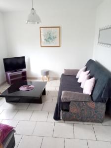 a living room with a bed and a couch at Maison de 2 chambres avec jardin clos et wifi a Epreville en Lieuvin in Épreville-en-Lieuvin