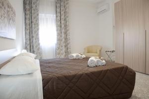 een slaapkamer met een bed met handdoeken en een stoel bij Il mare in città. Appartamento vista mare in Monopoli