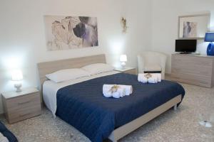 een slaapkamer met een groot bed en 2 handdoeken bij Il mare in città. Appartamento vista mare in Monopoli