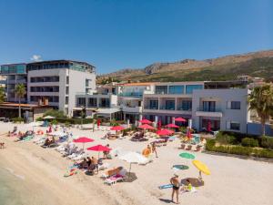 珀德垂那Luxury rooms Beach Mediteran的一群人坐在沙滩上，撑着遮阳伞