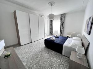 een slaapkamer met een groot bed en witte muren bij Il mare in città. Appartamento vista mare in Monopoli