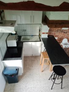a kitchen with a sink and a table with a stool at Maison de 2 chambres avec jardin clos et wifi a Epreville en Lieuvin in Épreville-en-Lieuvin