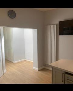 an empty kitchen with a clock on the wall at Beautiful stylish house near town centre in Rugby