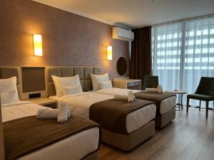 a hotel room with two beds and a television at Hotel Kanzler in Batumi