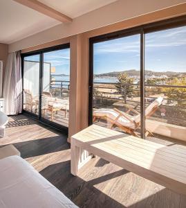 a bedroom with a bed and a balcony with a view at Rives d'Or Hôtel in La Seyne-sur-Mer