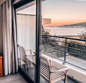 a balcony with two chairs and a view of the ocean at Rives d'Or Hôtel in La Seyne-sur-Mer