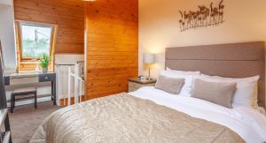a bedroom with a large bed with a desk and a desk at Anglers Arms in Alnwick +36 photos