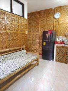 Zimmer mit einem Bett und einem Kühlschrank. in der Unterkunft Felipa Beach Residence - Jasmine in Dumaguete