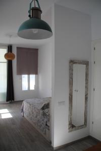een slaapkamer met een bed en een spiegel bij Apartamento “CALMA” in Tarifa