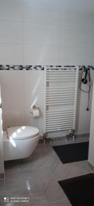 a bathroom with a tub and a toilet in it at Apartment Kleine Koje in Hedwigenkoog