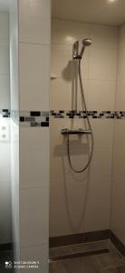 a shower with a hose in a bathroom at Apartment Kleine Koje in Hedwigenkoog