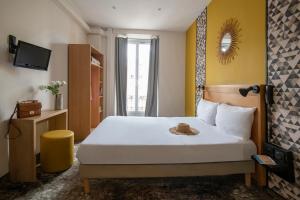 a hotel room with a bed with a hat on it at Hotel d'Ostende in Nice