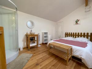 1 dormitorio con cama y bañera en L'ancienne étable, en Brens