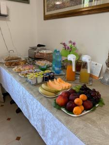 una mesa cubierta con platos de fruta y zumo en B&B Bentu de Mari, en Villasimius