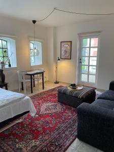 ein Schlafzimmer mit einem Bett, einem Sofa und einem Tisch in der Unterkunft Carlsminde ferielejlighed in Stenstrup