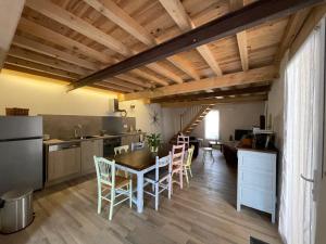 a kitchen and dining room with a table and chairs at L'ancienne étable in Brens