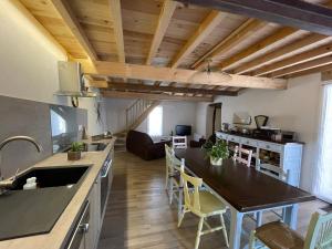 a kitchen with a table and a dining room at L'ancienne étable in Brens +8 photos