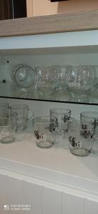 a shelf with glass dishes and bowls on it at Apartment Kleine Koje in Hedwigenkoog