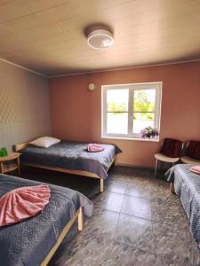 a room with three beds and a window at Kihnu Külalistemaja in Lemsi