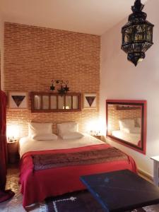 a bedroom with a large bed and a brick wall at Les Bains de Fez Tara in Fez