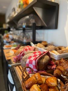 Ein Haufen Brot und Gebäck auf dem Tisch. in der Unterkunft Hof van Slenaken - Hotel & Apartments in Slenaken