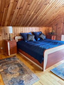 a bedroom with a blue bed with a wooden ceiling at BESKIDIUM - uroczy dom Brenna in Brenna