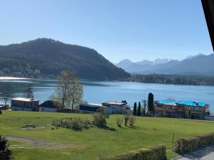 a view of a large lake with houses and mountains at Lieblingsplatzl - Das Apartmenthaus in Drobollach am Faaker See