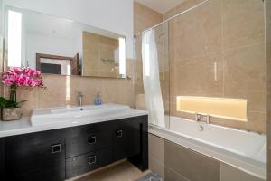 a bathroom with a sink and a tub and a mirror at GuestReady - Extravagant 2BR Apt in London in London