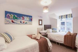 een slaapkamer met 2 bedden en een wastafel bij Rosevean Cottage St Agnes in St. Agnes 