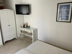 Habitación con escritorio y TV en la pared. en La casa di Murphy en Porto Recanati