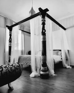 um quarto com uma cama e um poste com cortinas em Hotel Rural Luna Llena em Torremocha de Jarama