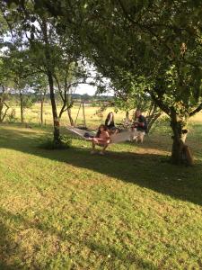 Carlsminde ferielejlighed في Stenstrup: مجموعة من الناس يجلسون على أرجوحة في الحديقة