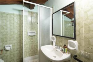 Un baño con lavabo y ducha con espejo. en Stone built farmhouse Antica Torre by VacaVilla, en Lamole 22 fotos más