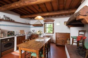 Una cocina con una mesa de madera en una habitación. en Stone built farmhouse Antica Torre by VacaVilla, en Lamole