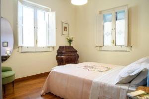 索倫托的住宿－La Camelia Apartment，一间卧室设有一张床和两个窗户。