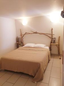 una camera con un grande letto con testiera in legno di Appartement le loft a Saintes-Maries-de-la-Mer