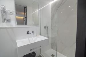 a white bathroom with a sink and a mirror at Hotel La Milagrosa in Alicante