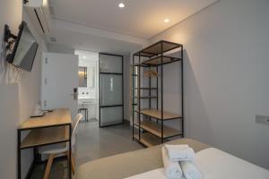 a room with a bed and a desk and a kitchen at Hotel La Milagrosa in Alicante